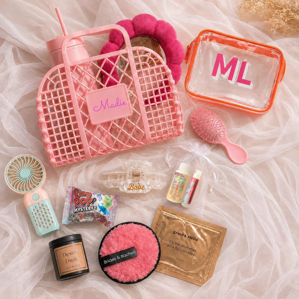 Boujee babe bachelorette gift bag flat lay with personalized pink jelly bag, custom tumbler, candle, and beauty essentials