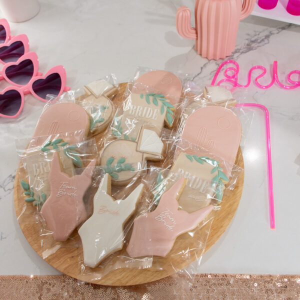 Boho Bach bachelorette theme includes table top cookies, bride straw and sunglasses.