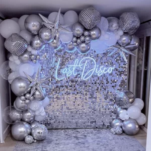 Last Disco Bachelorette Theme photo backdrop with silver and white balloons on a silver sequin wall.