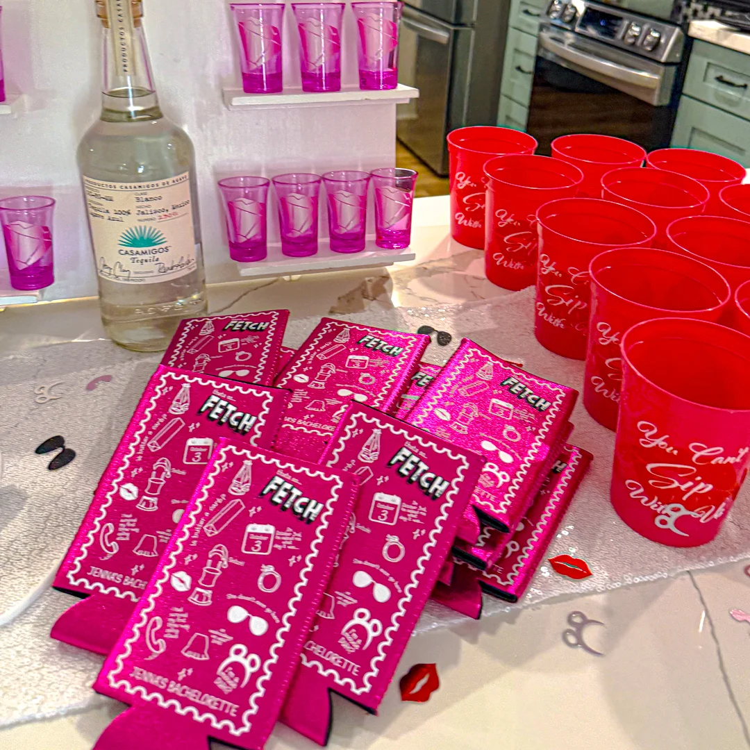 Mean Girls table decor with pink Fetch tumblers and pink hangover kit boxes