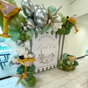 Scottsdale Bach Club bachelorette backdrop with sage green balloon garland, martini mylar balloons, and striped desert cactus sign